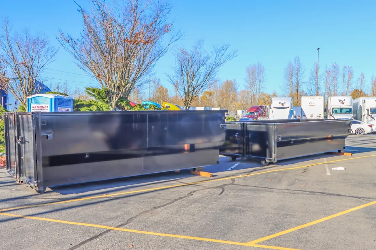 Professional dumpster rental service with roll-off container on residential driveway in Brockport
